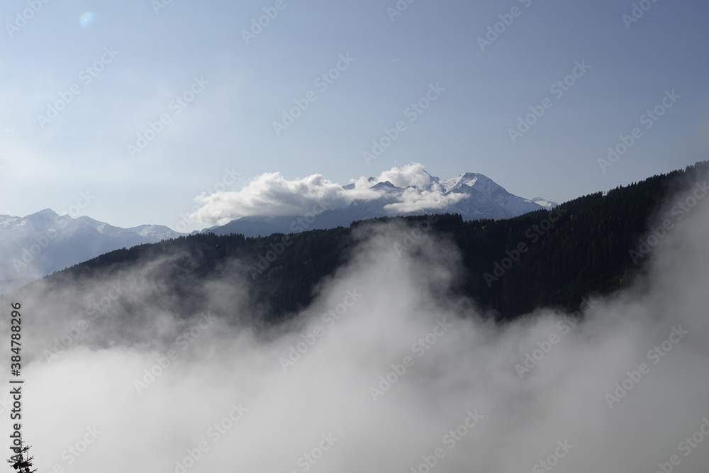 blue clear sky on the mountains with view of a foggy valley and the alps