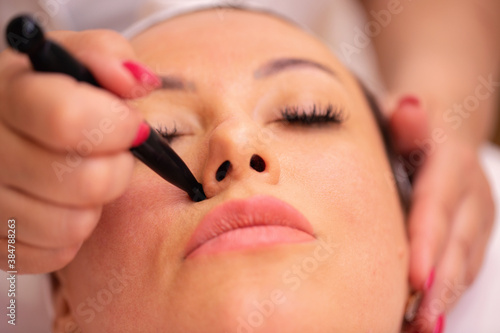 Middle aged woman having a wrinkle reduction therapy with a stone wand