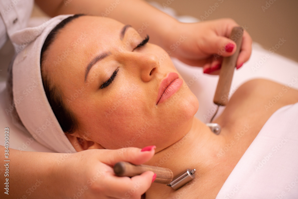 Woman getting a neck massage with facial beauty rollers Woman getting a neck massage with facial beauty rollers