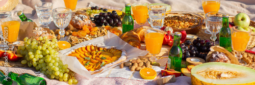 A picnic in the park with beautiful glasses, fruits and pastries.