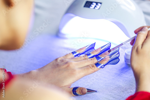 Woman applying nail builder gel. nail extension sticker.