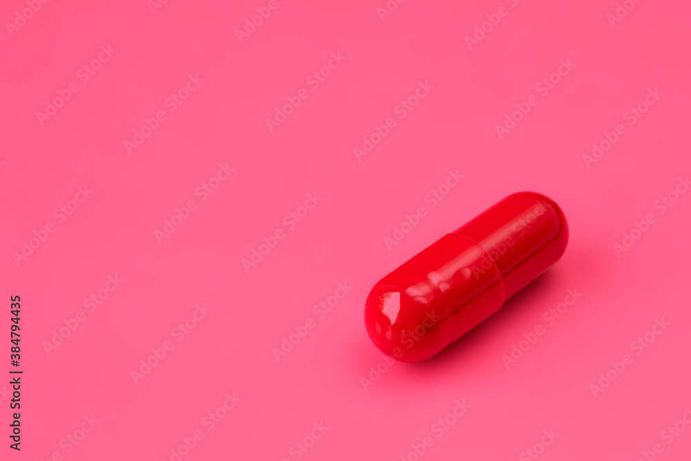 One red pill to increase potency on a red background. Men's health concept One red pill to increase potency on a red background. Men's health concept