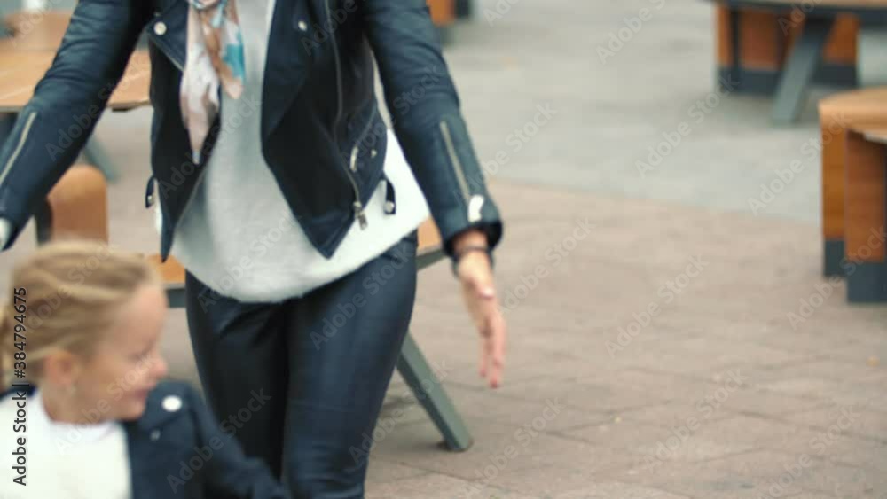 mom and daughter are walking on the street mom and daughter are walking on the street