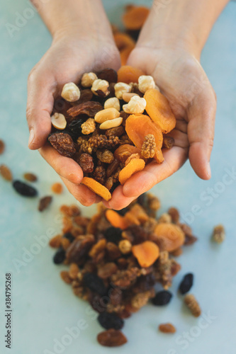 a handful of mixed dried fruit, on green background