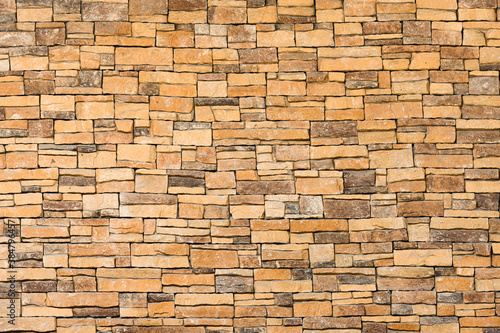 background and texture of yellow decorative stone wall surface.