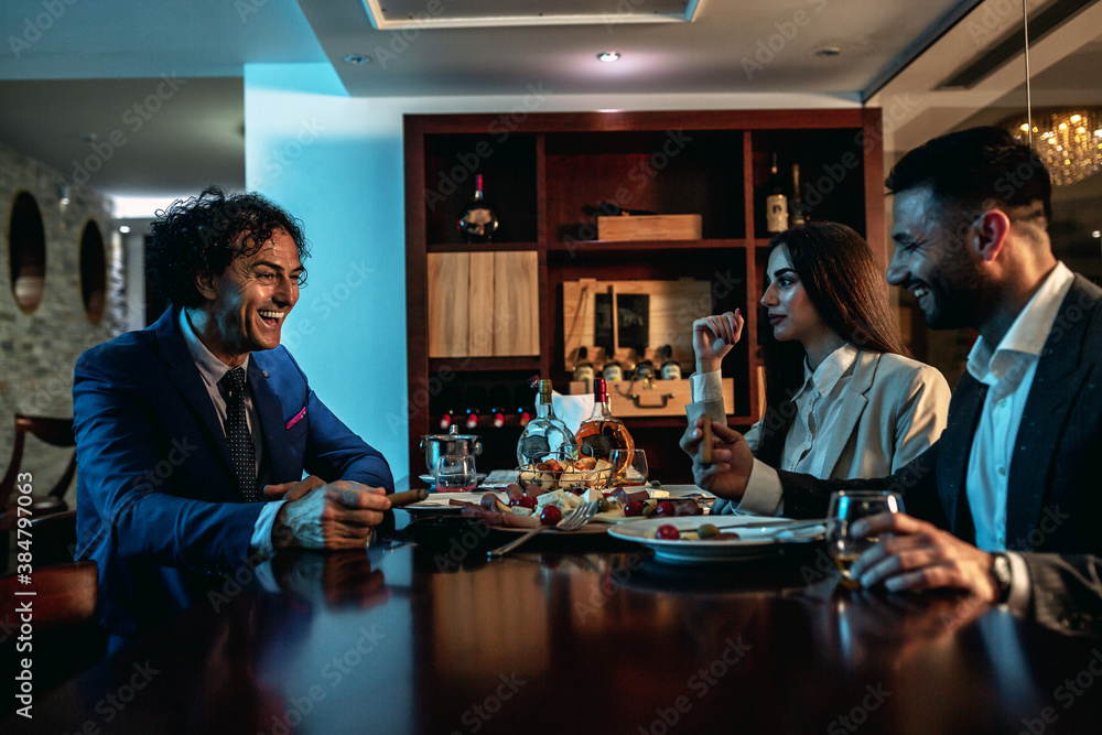People dressed in business suits sitting at a dinner table