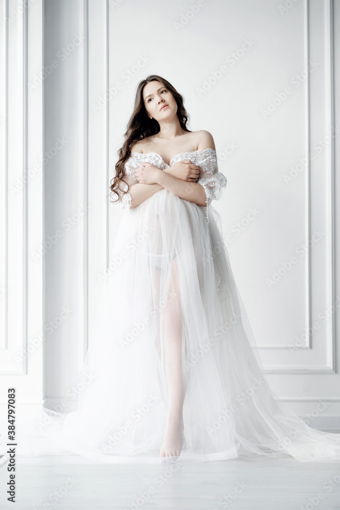 beautiful young pregnant woman in long white negligee