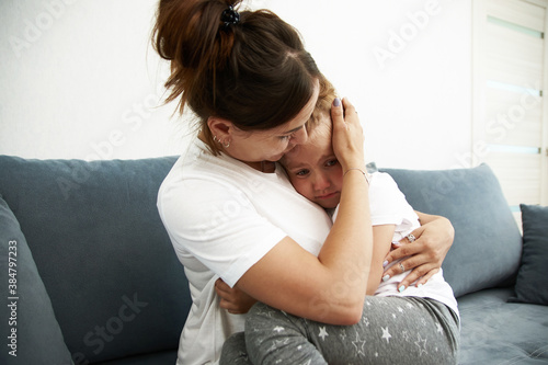 The mother pities daughter.The little girl is sad. Mother becalms litlle girl photo