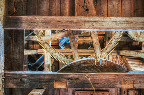 Obraz na plátně Solid wooden beam supports wooden cog and gears in an old windmill for wheat grinding