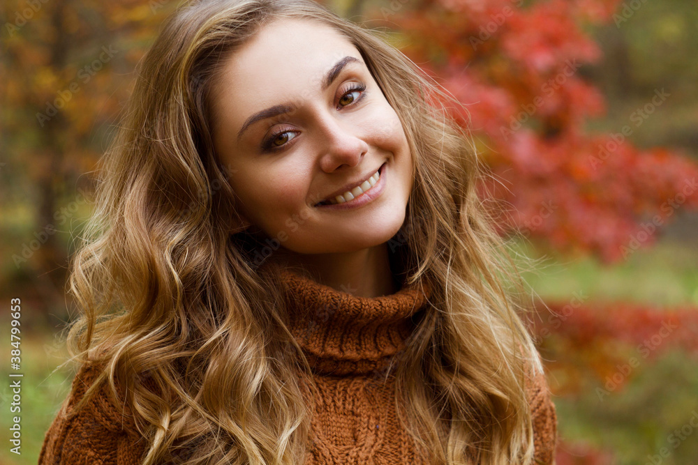 Young happy beautiful woman with curly hair wearing sweather having good time in autumn park Young happy beautiful woman with curly hair wearing sweather having good time in autumn park