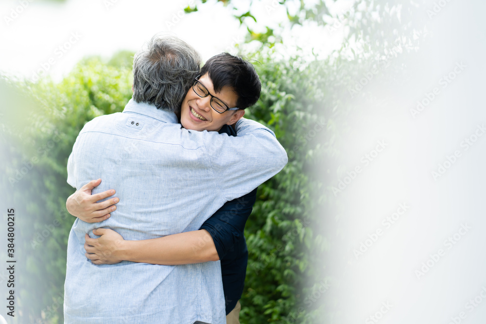 Senior Asian Father With Adult grown Son hugging outdoors Senior Asian Father With Adult grown Son hugging outdoors