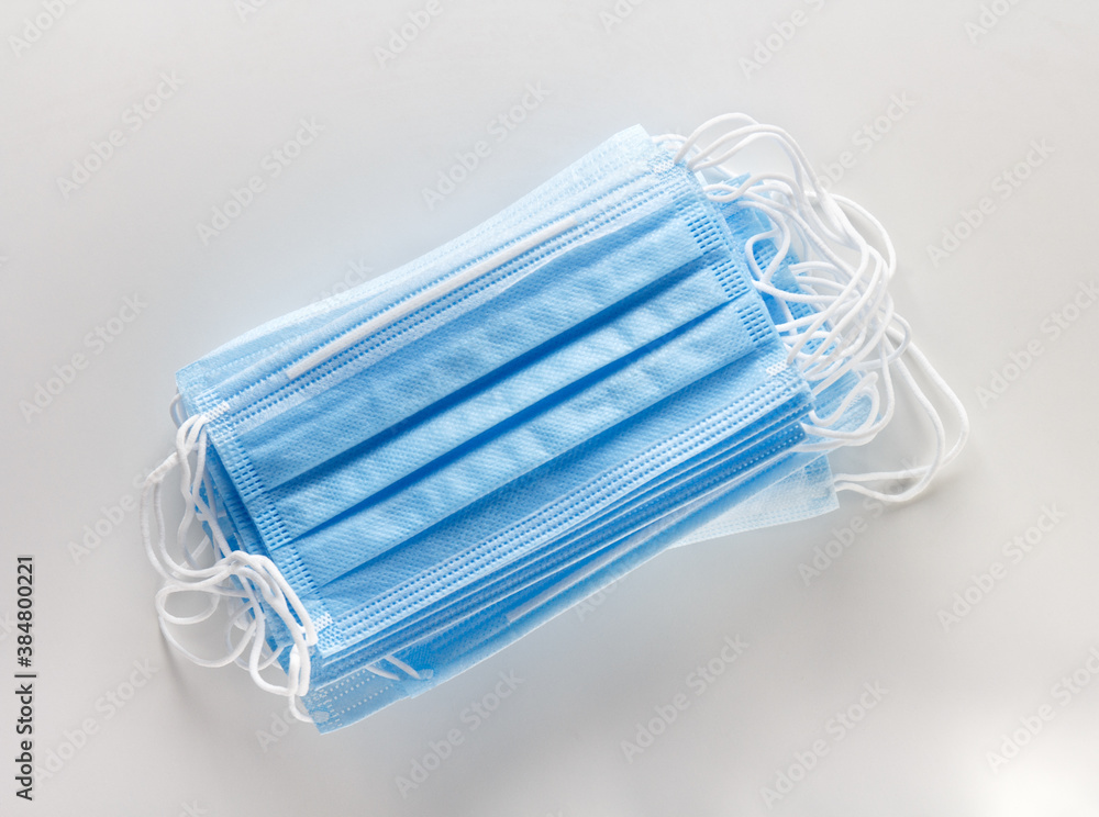 stack of disposable protective blue masks on a white background stack of disposable protective blue masks on a white background