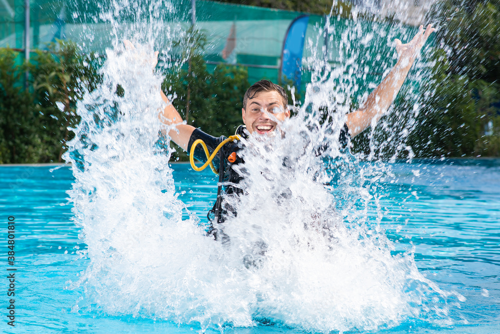 a man splashes in the pool, he is wearing a diving suit