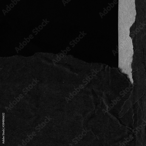 Black torn paper collage close-up. Texture made from various paper and cardboard parts. Damaged old paper background. Vintage blank wallpaper. Material design backdrop.
