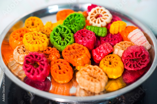 shot of colorful Fryums being deep fried in hot oil bubbling and sizzling with bubbles forming and size increasing of this popular north indian snack and street food photo