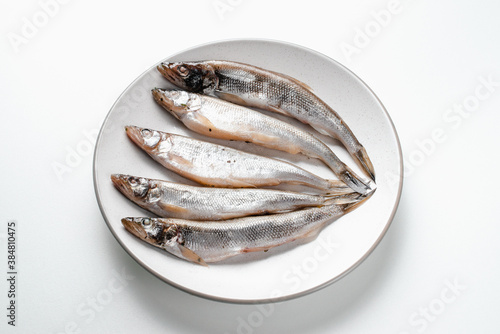 Fish lies on plate on white background