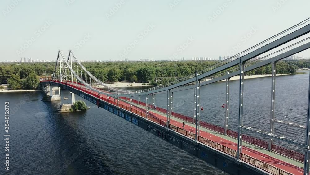 People walk and ride their bicycles on the pedestrian bridge over the river. People walk and ride their bicycles on the pedestrian bridge over the river.