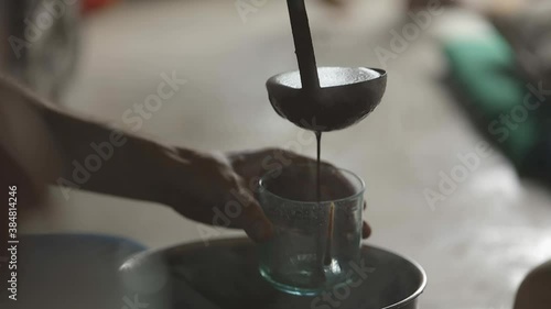 Pouring liquid ceremonial cacao into a cup photo