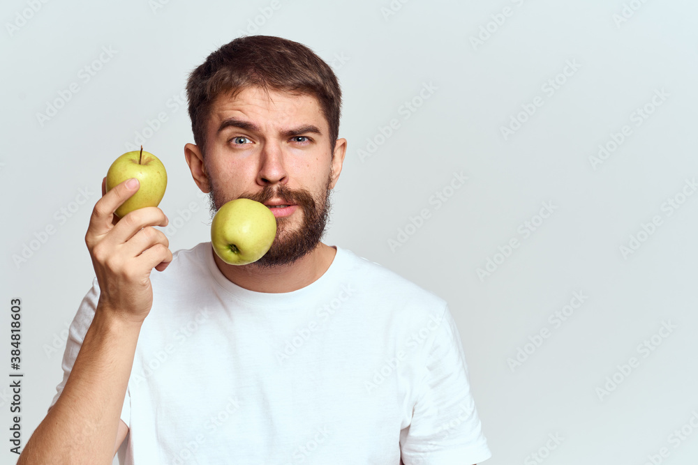 Energetic man with apples health vitamins diet and lifestyle white t-shirt cropped view Energetic man with apples health vitamins diet and lifestyle white t-shirt cropped view