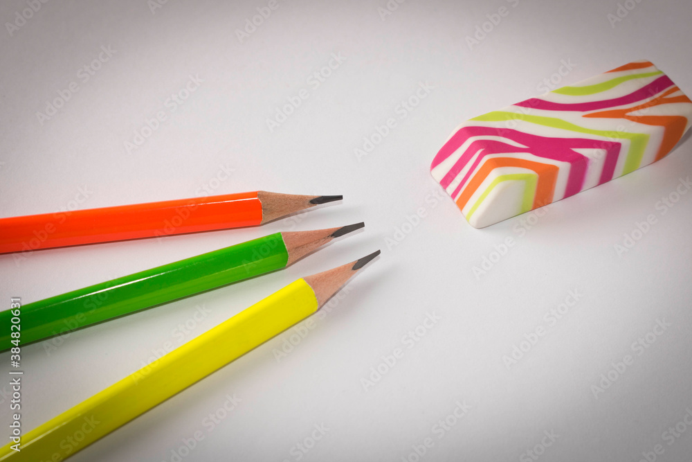 Fototapeta premium Colorful eraser and simple pencils on a light background. Close up. Selective focus.