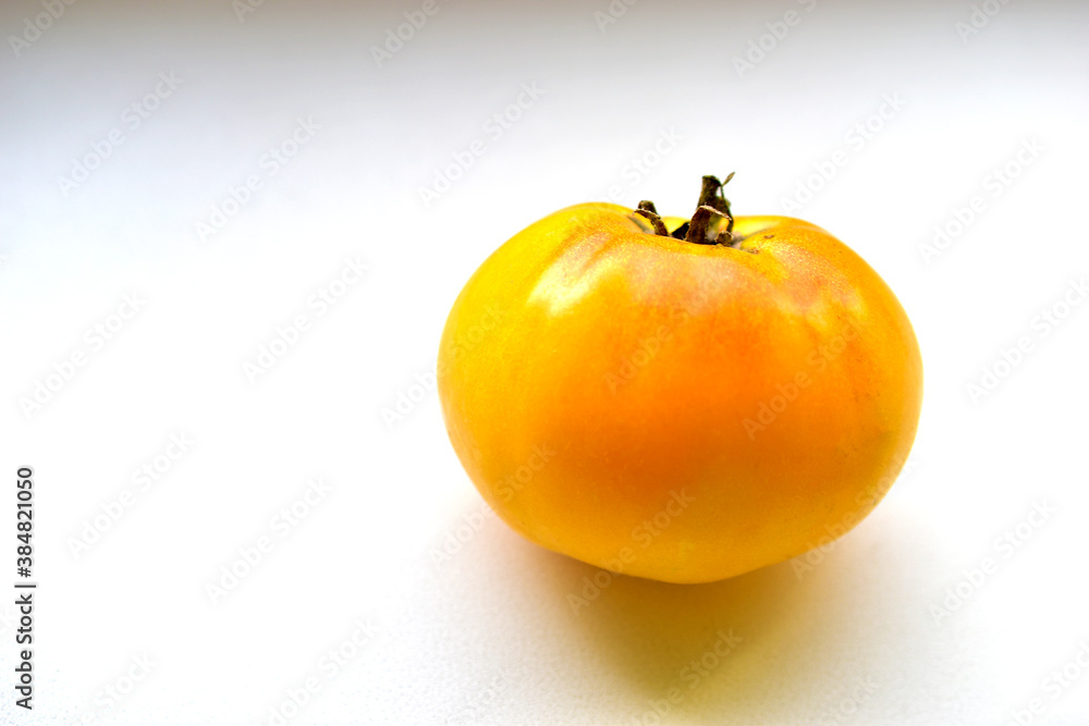 Yellow tomato on a white background close-up Yellow tomato on a white background close-up