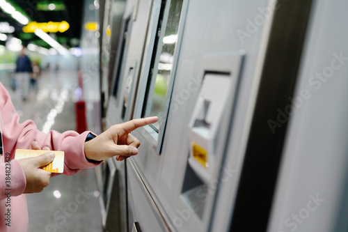 Photography Woman choosing the destination on subway train ticket machine. T