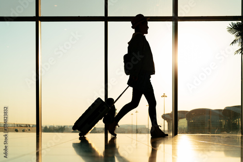 walking traveler with suitcase, passenger for tour in the airpor photo