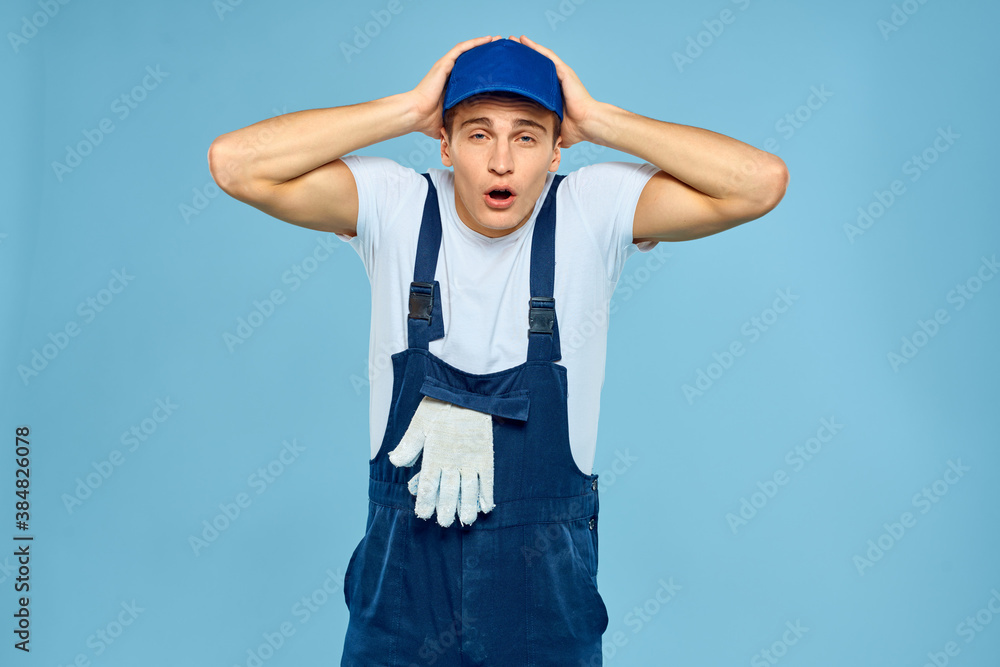 Fototapeta premium Working man in uniform of gloves loader rendering service blue background
