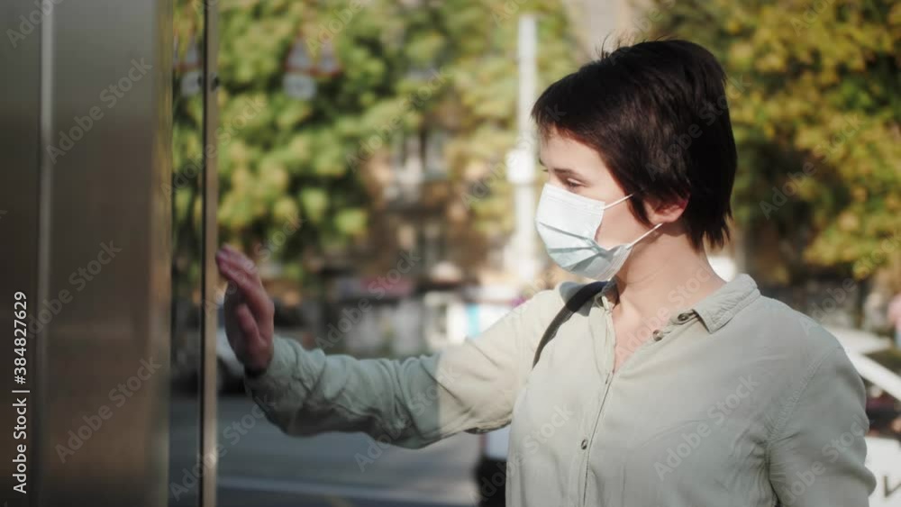 Woman in medical mask using interactive touchscreen display in the city, scrolling and touching. Entertainment and technology concept. Woman in medical mask using interactive touchscreen display in the city, scrolling and touching. Entertainment and technology concept.