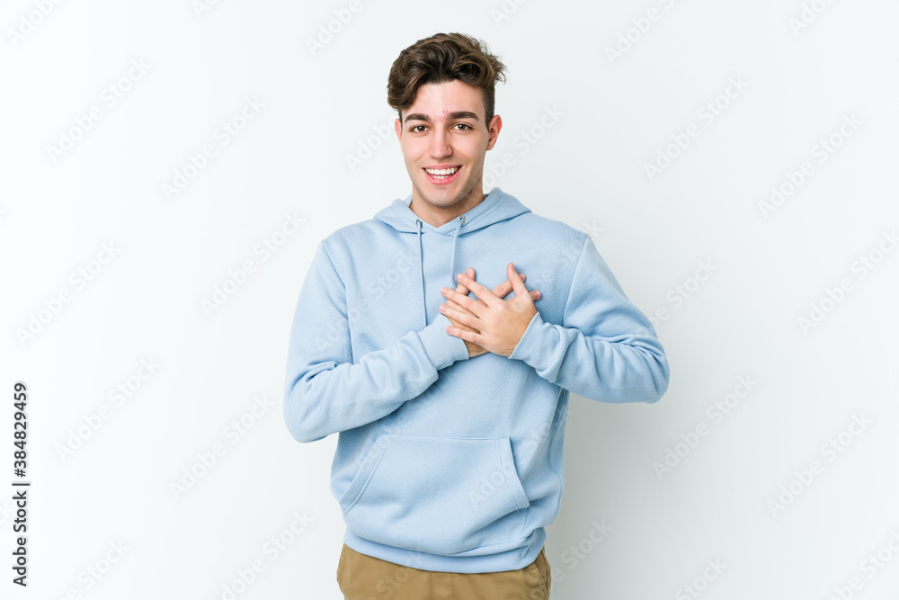 Young caucasian man isolated on white background has friendly expression, pressing palm to chest. Love concept. Young caucasian man isolated on white background has friendly expression, pressing palm to chest. Love concept.