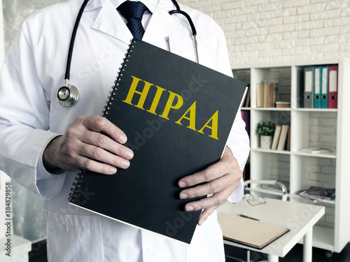 Doctor holds papers about HIPAA certification. Health Insurance Portability and Accountability Act.
