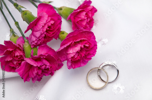 Beautiful White Carnation Flowers with Wedding Rings on White Background