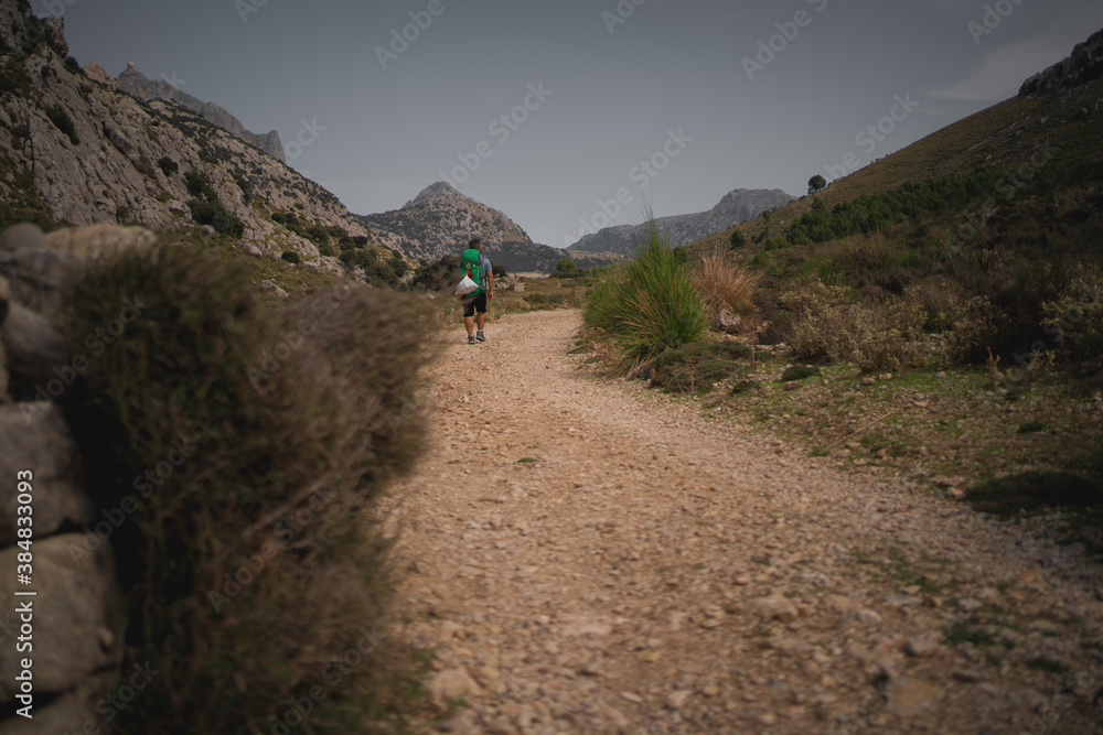 Hiker walking through a trail in Serra de Tramuntana, Mallorca