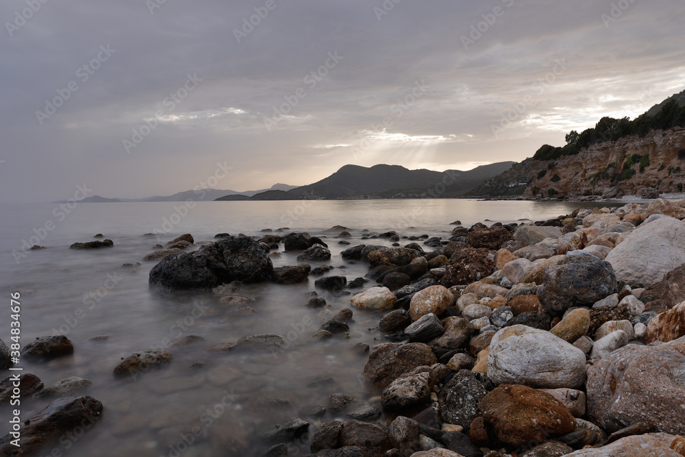 Rocky stretch of coast of the Mediterranean Sea on the Greek Aegean island of Samos with a calm water surface. Rocky stretch of coast of the Mediterranean Sea on the Greek Aegean island of Samos with a calm water surface.