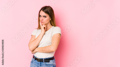 Young caucasian woman isolated on pink background unhappy looking in camera with sarcastic expression. © Asier