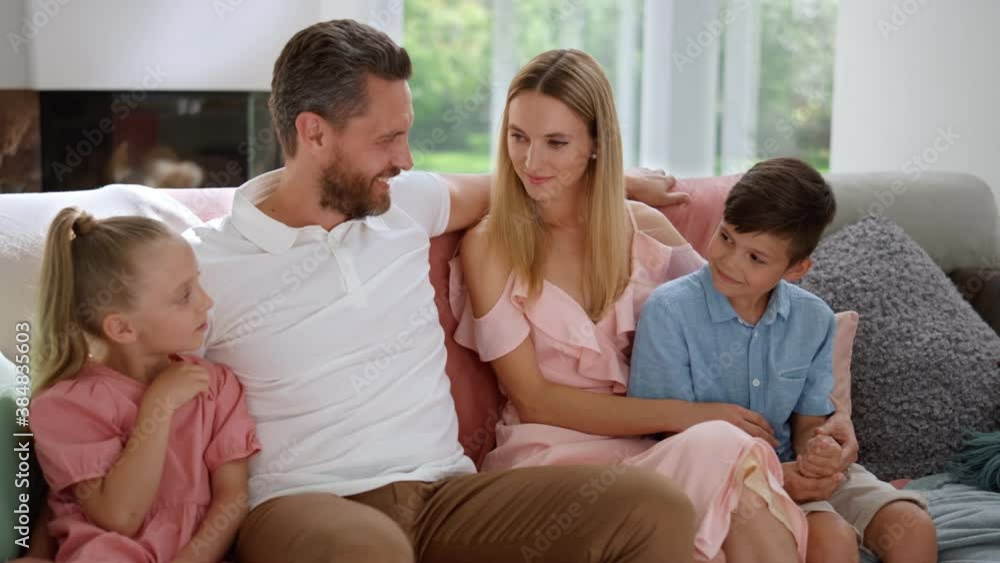 Attractive mother and father hugging kids. Happy parents looking at children Attractive mother and father hugging kids. Happy parents looking at children