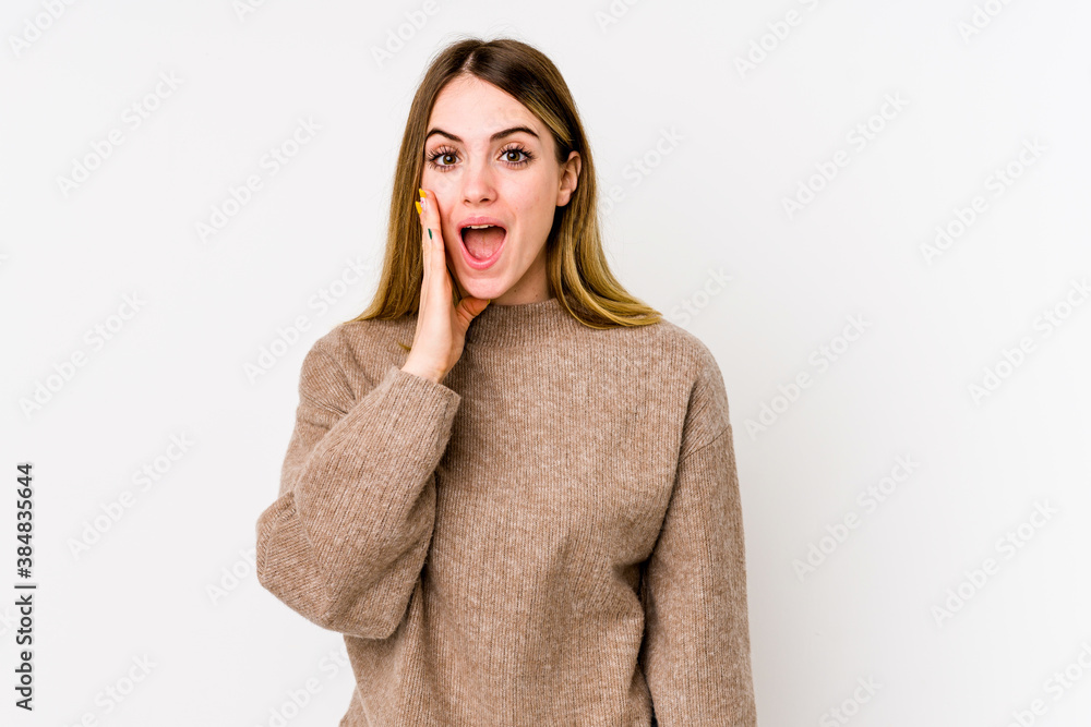 Young caucasian woman isolated on white background shouts loud, keeps eyes opened and hands tense. Young caucasian woman isolated on white background shouts loud, keeps eyes opened and hands tense.