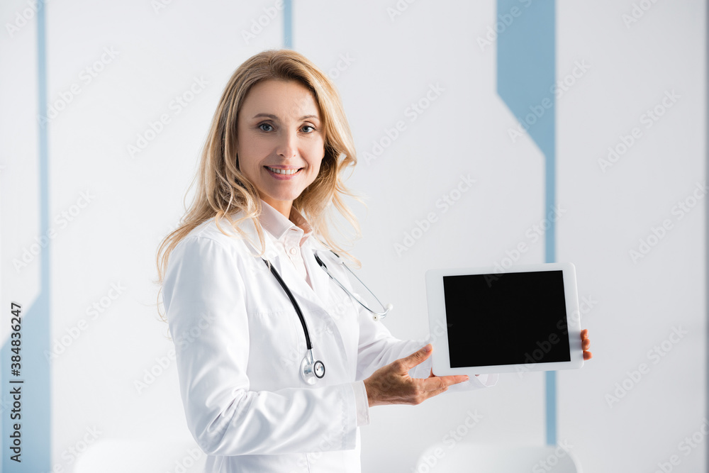Doctor pointing with hand at digital tablet in clinic Doctor pointing with hand at digital tablet in clinic