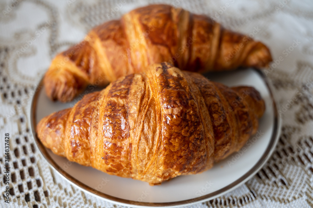 Two fresh baked puff croissants, traditional French breakfast