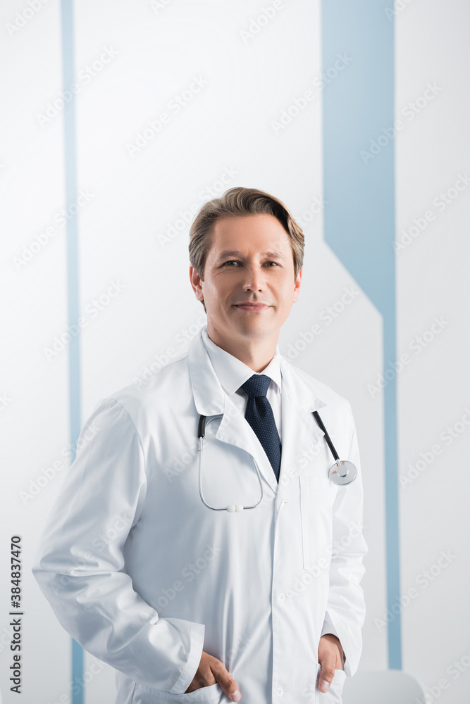 Doctor with stethoscope and hands in pockets looking at camera in hospital Doctor with stethoscope and hands in pockets looking at camera in hospital