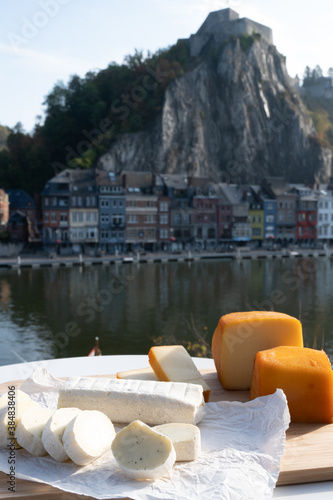 Cheese collection, Belgian abbey cheeses made with brown trappist beer and fine herbs and view on Maas river in Dinant, Wallonia, Belgium photo