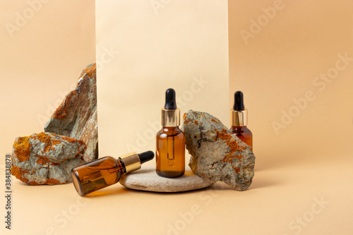 An amber bottle for essential oils and cosmetics stands next to the stone. Glass bottle. Dropper, spray bottle. Natural cosmetics concept. photo