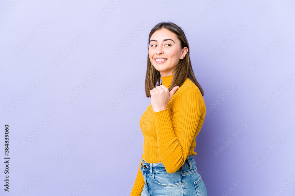Young caucasian woman points with thumb finger away, laughing and carefree. Young caucasian woman points with thumb finger away, laughing and carefree.