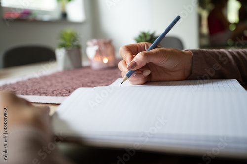 Bild auf Leinwand Woman writing in blank notebook on wooden desk