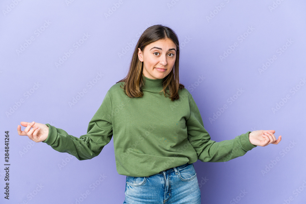 Young caucasian woman doubting and shrugging shoulders in questioning gesture. Young caucasian woman doubting and shrugging shoulders in questioning gesture.