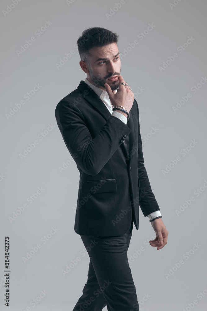 Eager elegant man holding hand on chin and looking away Eager elegant man holding hand on chin and looking away