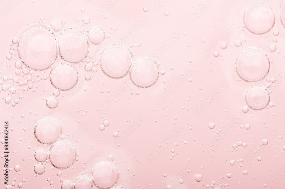 Transparent texture of moisturizing serum on a pink background. Gel water lotion for skincare. Cosmetic liquid beauty product with retinol and vitamins for face and body skin care.
