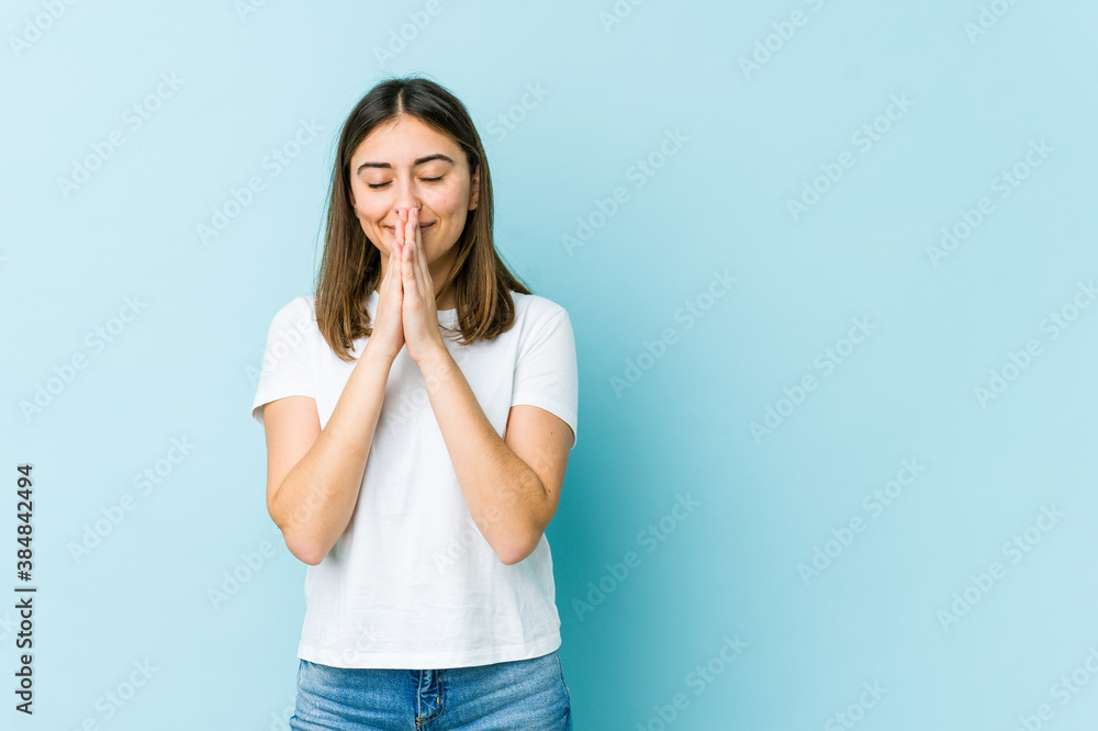 Young caucasian woman holding hands in pray near mouth, feels confident. Young caucasian woman holding hands in pray near mouth, feels confident.