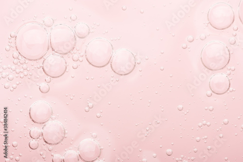 Obraz na płótnie Transparent texture of moisturizing serum on a pink background. Gel water lotion for skincare. Cosmetic liquid beauty product with retinol and vitamins for face and body skin care. w salonie