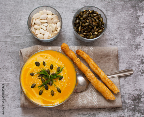 pumpkin cream soup. Pumpkin soup with pumpkin seeds and baguette. Autumn soup